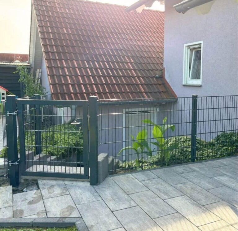 Tor als nahtlose Erweiterung eines Doppelstabmattenzauns auf einem Grundstück