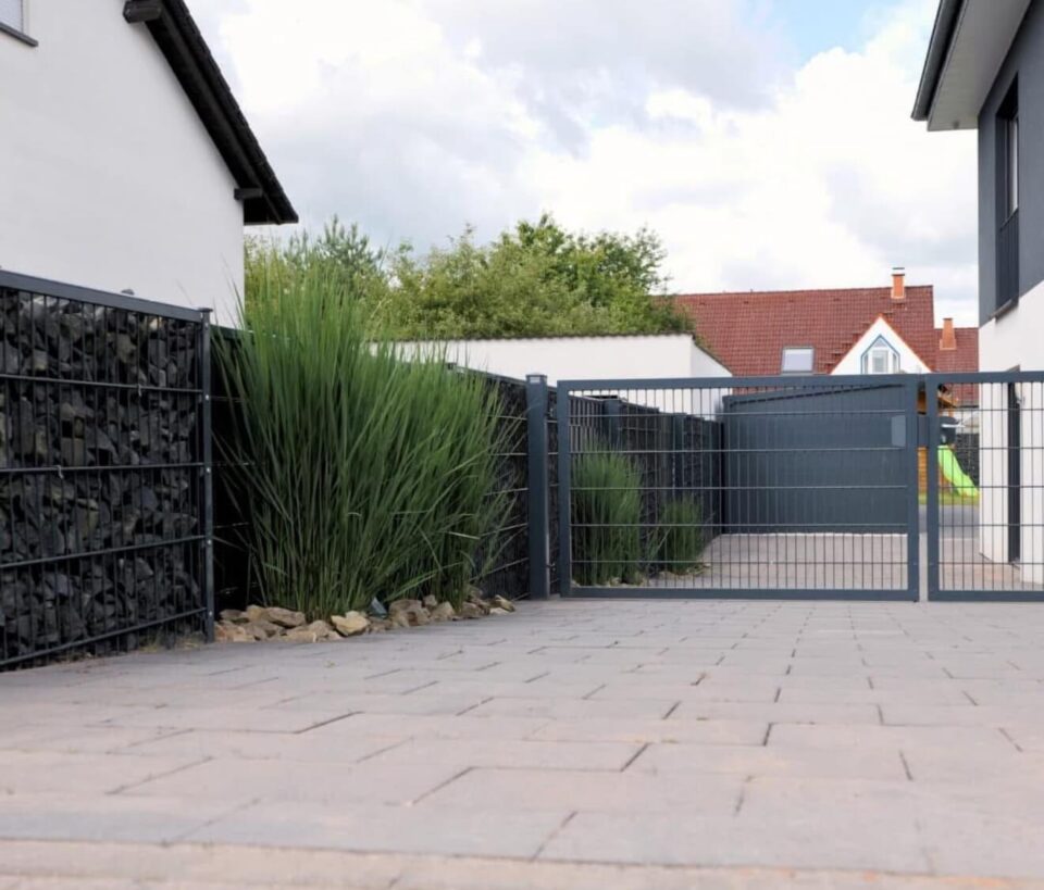 Zweiflügeliges Drehtor aus Metall als Einfahrtstor mit modernem Zaunsystem