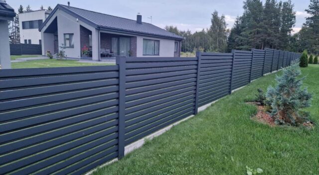 Schwarzer Lamellenzaun als moderner Sichtschutz im privaten Garten
