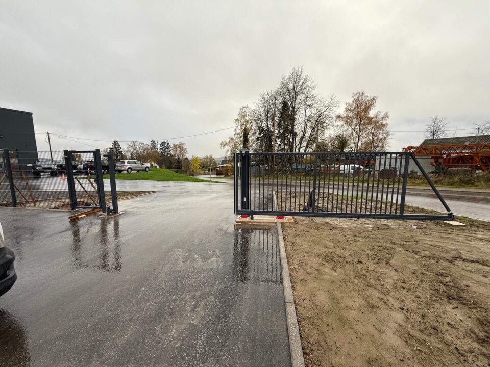 Modernes Schiebetor aus Metall mit geradem Lauf entlang des Zauns